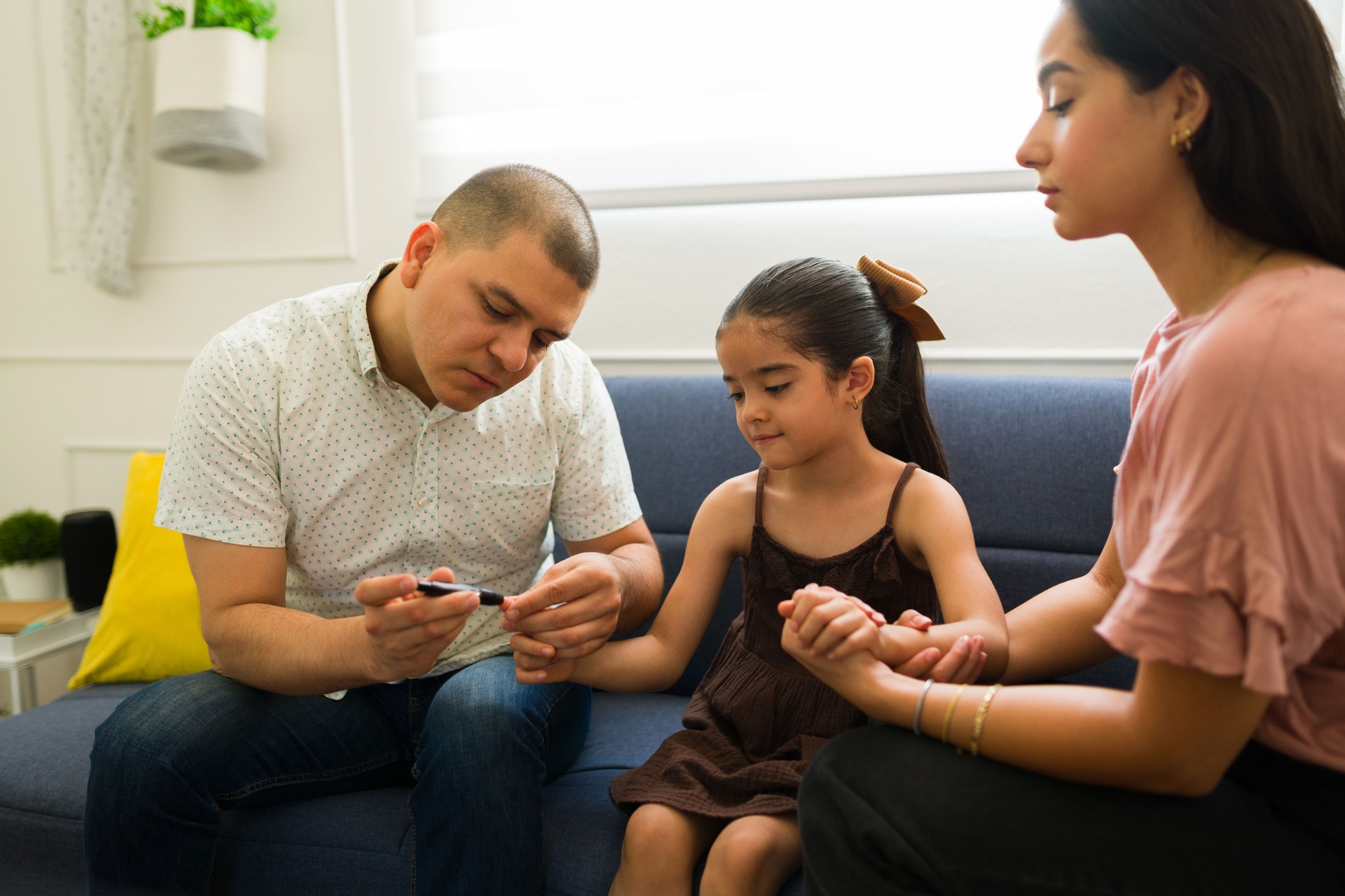 Dad checking the sugar levels of her child with diabetes